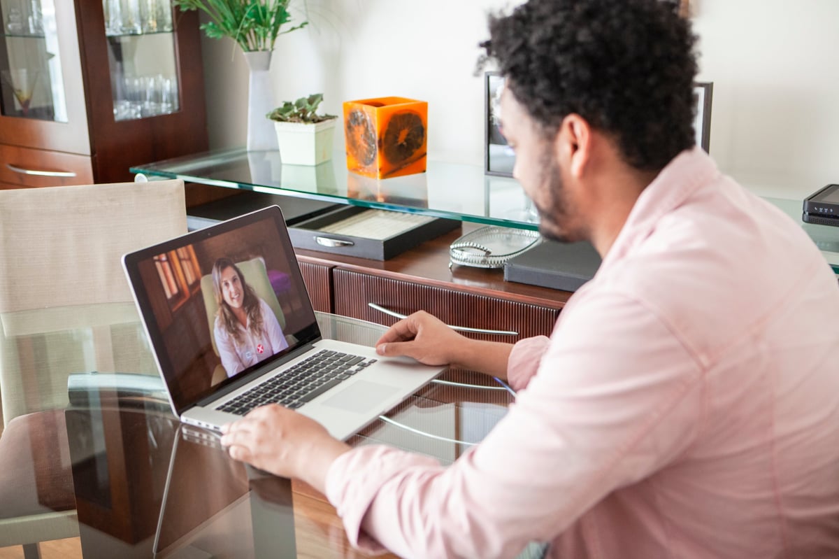 An African American young man participating in a supportive counseling session from home